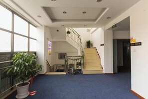 A hotel lobby with a blue carpet, a staircase, and a potted plant. - Kuaizhilv Express Chain Hotel (Kunshan)