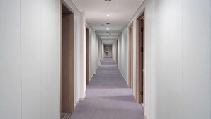 A long, narrow hotel corridor with a carpeted floor and doors on both sides. - Kuaizhilv Express Chain Hotel (Kunshan)