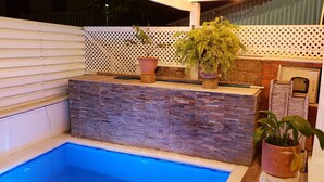 A swimming pool with a stone wall and potted plants. - HOTEL VERANO AZUL (San Andrés)