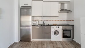 A modern kitchen with stainless steel appliances, white cabinets, and a wooden floor. - 'Casa Graham' Apartment with Sea View, Balcony and Wi-Fi (Tazacorte)
