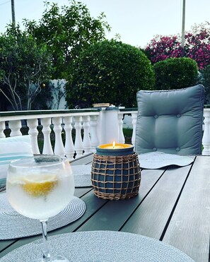 Een tafel met een kaars, een glas water met citroen en een stoel.