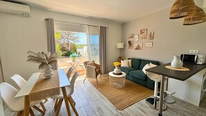 Un salon moderne comprenant un coin repas, un canapé, une table basse et une vue sur l’extérieur.