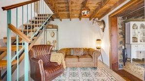 A wooden staircase, a leather armchair, a sofa, a patterned rug, and a cabinet with glass doors. - Holiday Home 'Caldera De Taburiente Rural' with Mountain View, Private Terrace and Wi-Fi (El Paso)