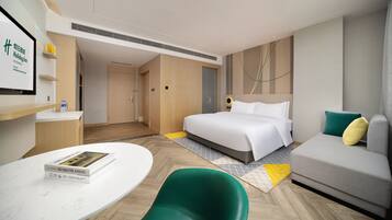Una habitación de hotel con una cama, un sofá, un escritorio y una silla.