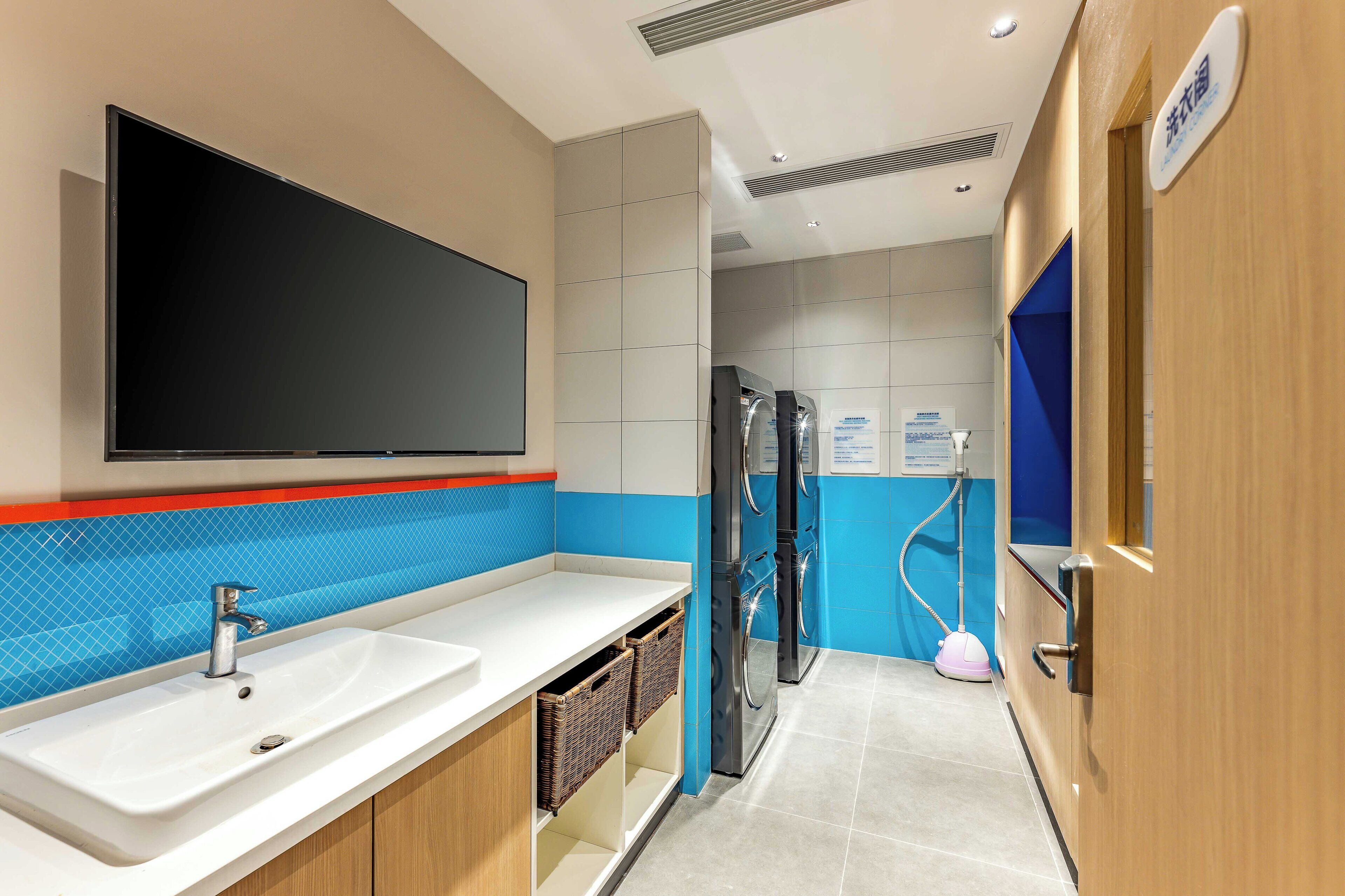 A modern bathroom with a large mirror, a sink, and a toilet.