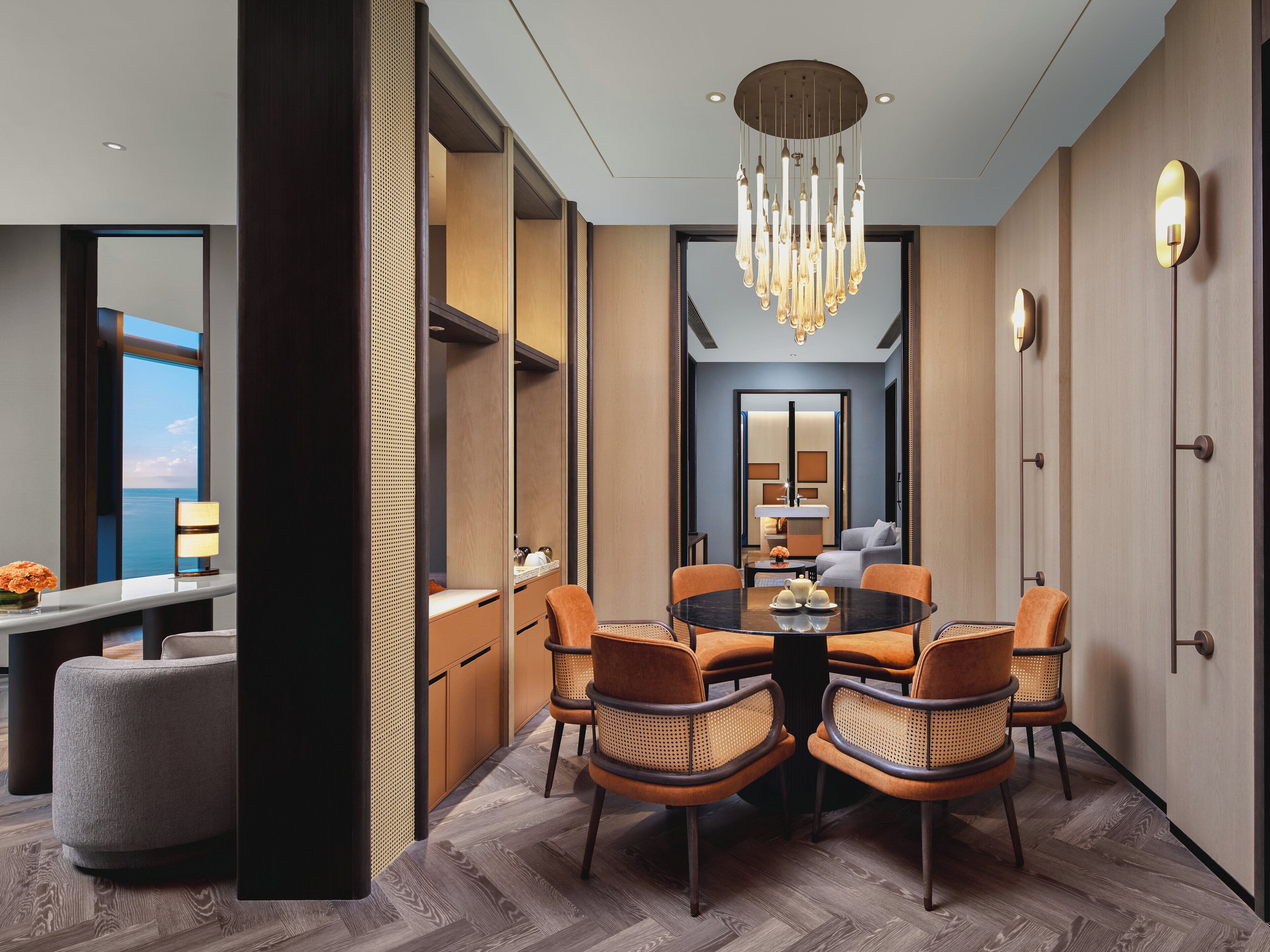Ein modernes Hotelzimmer mit Essbereich, einem großen Spiegel und Blick aufs Meer.