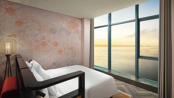 Una habitación de hotel moderna con un ventanal que ofrece vistas al agua.
