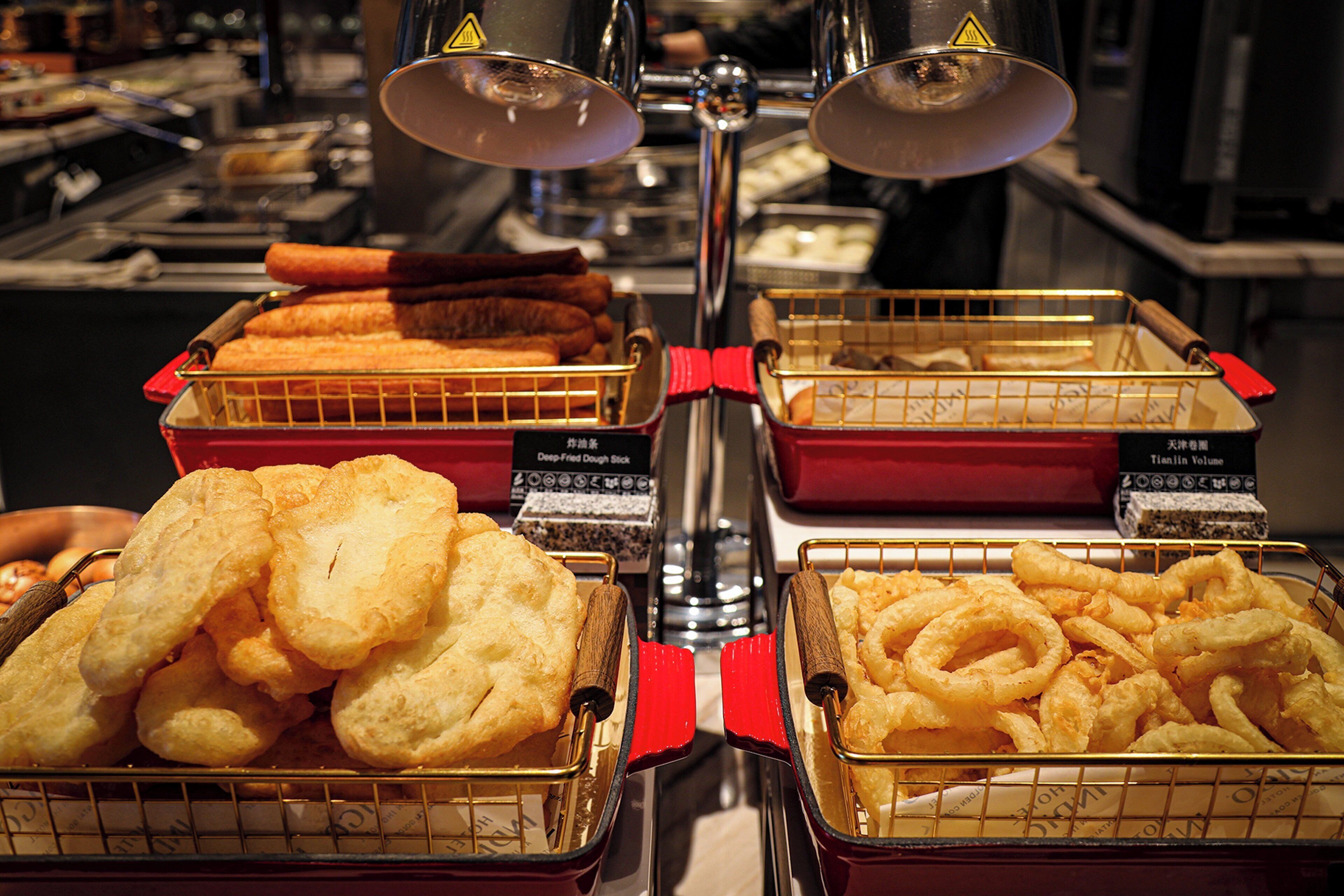 A buffet with various fried foods displayed in trays.