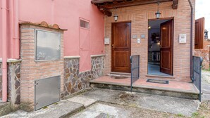 Un bâtiment à la façade en briques, doté d’une porte en bois et d’un portail en métal.