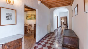 A hallway with a checkered floor, wooden furniture, and framed artwork on the walls. - Apartment 'Villa Caselunghe' with Shared Pool, Wi-Fi and Air Conditioning (Siena)