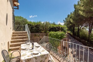 A dining table set outdoors with a view of a stone staircase and greenery. - Apartment 'Villa Caselunghe' with Shared Pool, Wi-Fi and Air Conditioning (Siena)