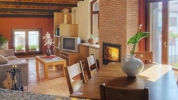 Un soggiorno con camino, mobili in legno e televisore.