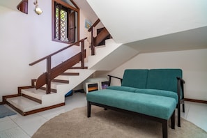 A staircase with wooden railings, a teal sofa, and a carpeted floor.