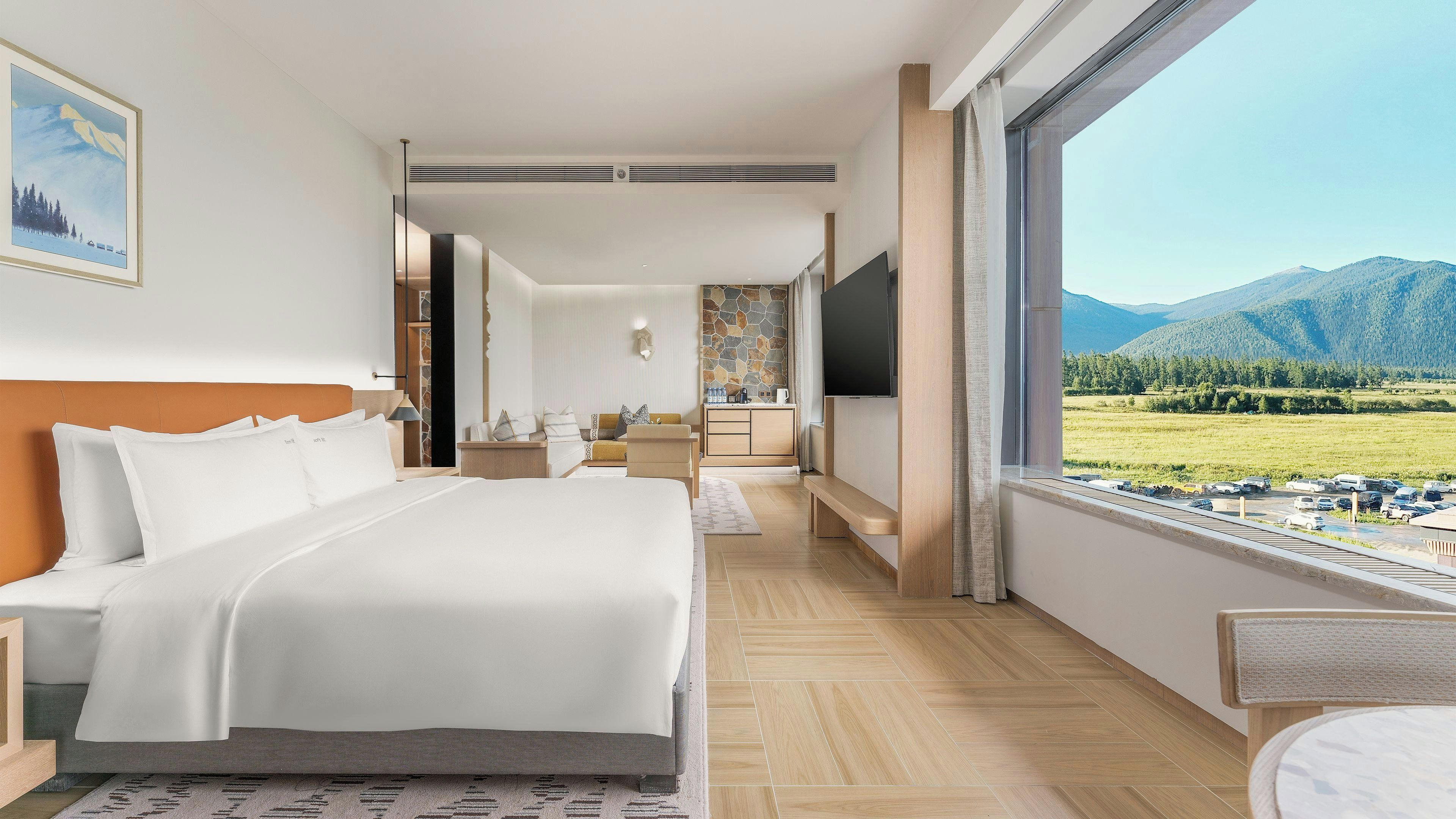 Une chambre d’hôtel moderne dotée d’un grand lit, d’une télévision et offrant une vue sur un paysage montagneux.