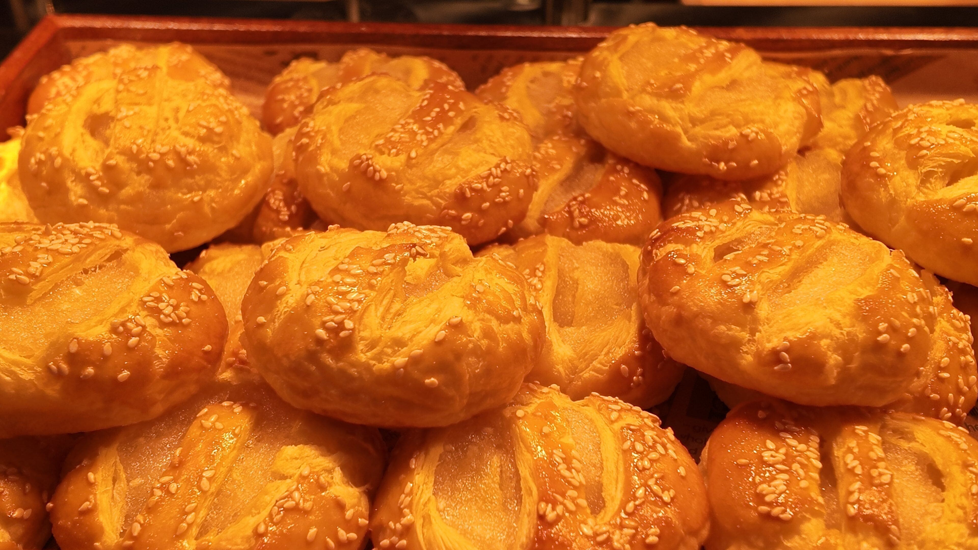 A tray of round, sesame-seed-topped pastries.
