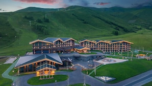 Um hotel moderno com vários edifícios, um jardim bem cuidado e uma paisagem montanhosa.