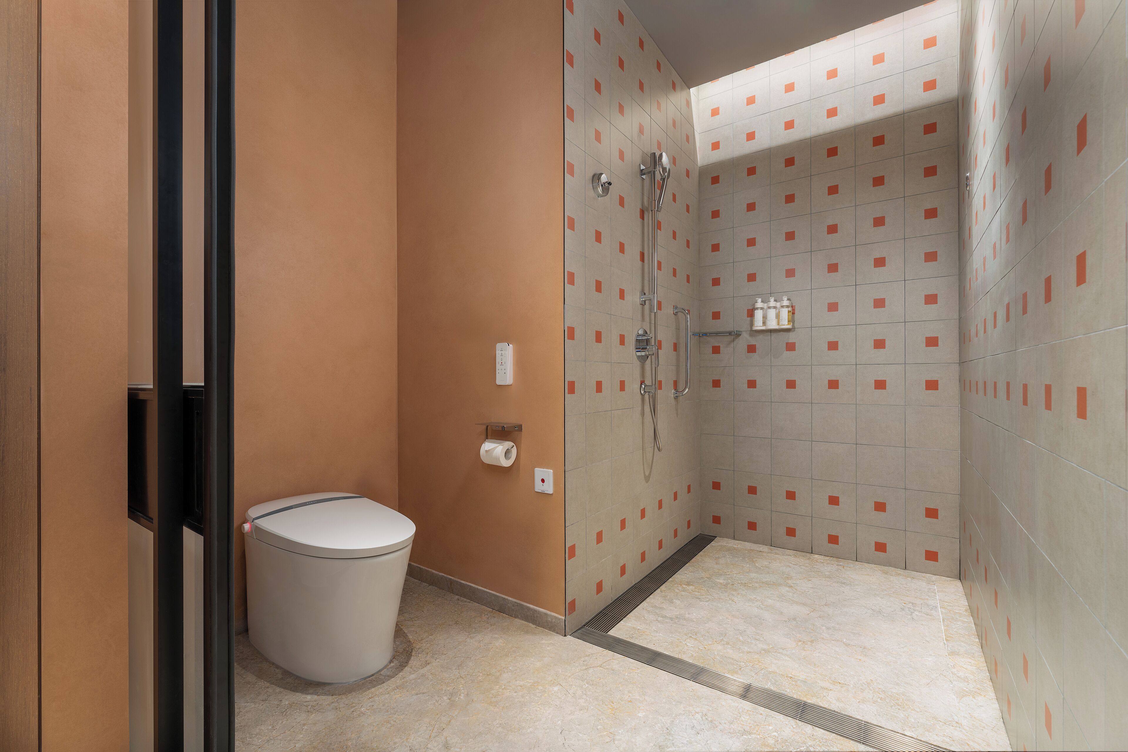 A bathroom with a toilet, shower, and tiled walls.