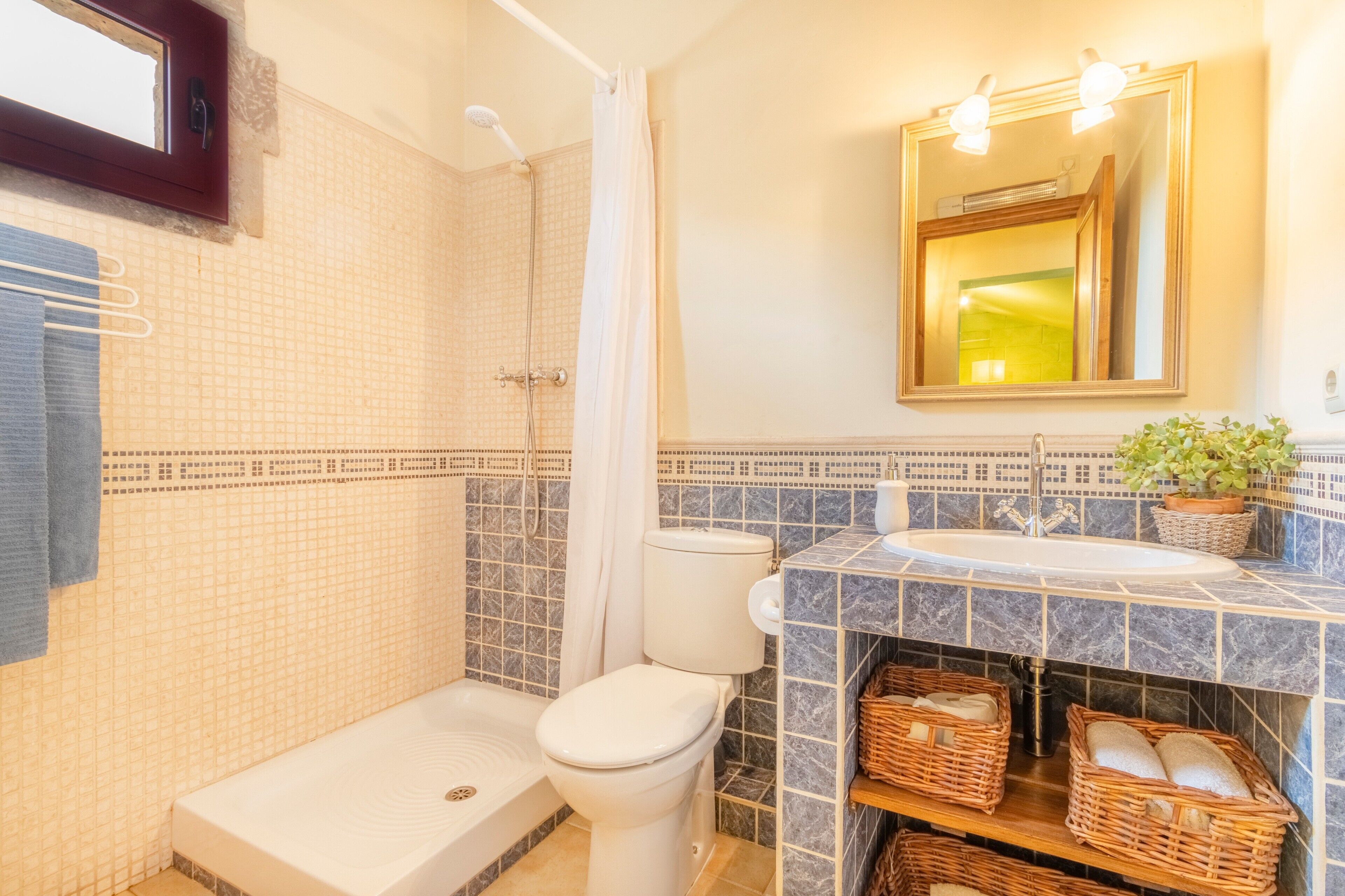 Ein Badezimmer mit Badewanne, Toilette, Dusche und Waschbecken mit Spiegel.