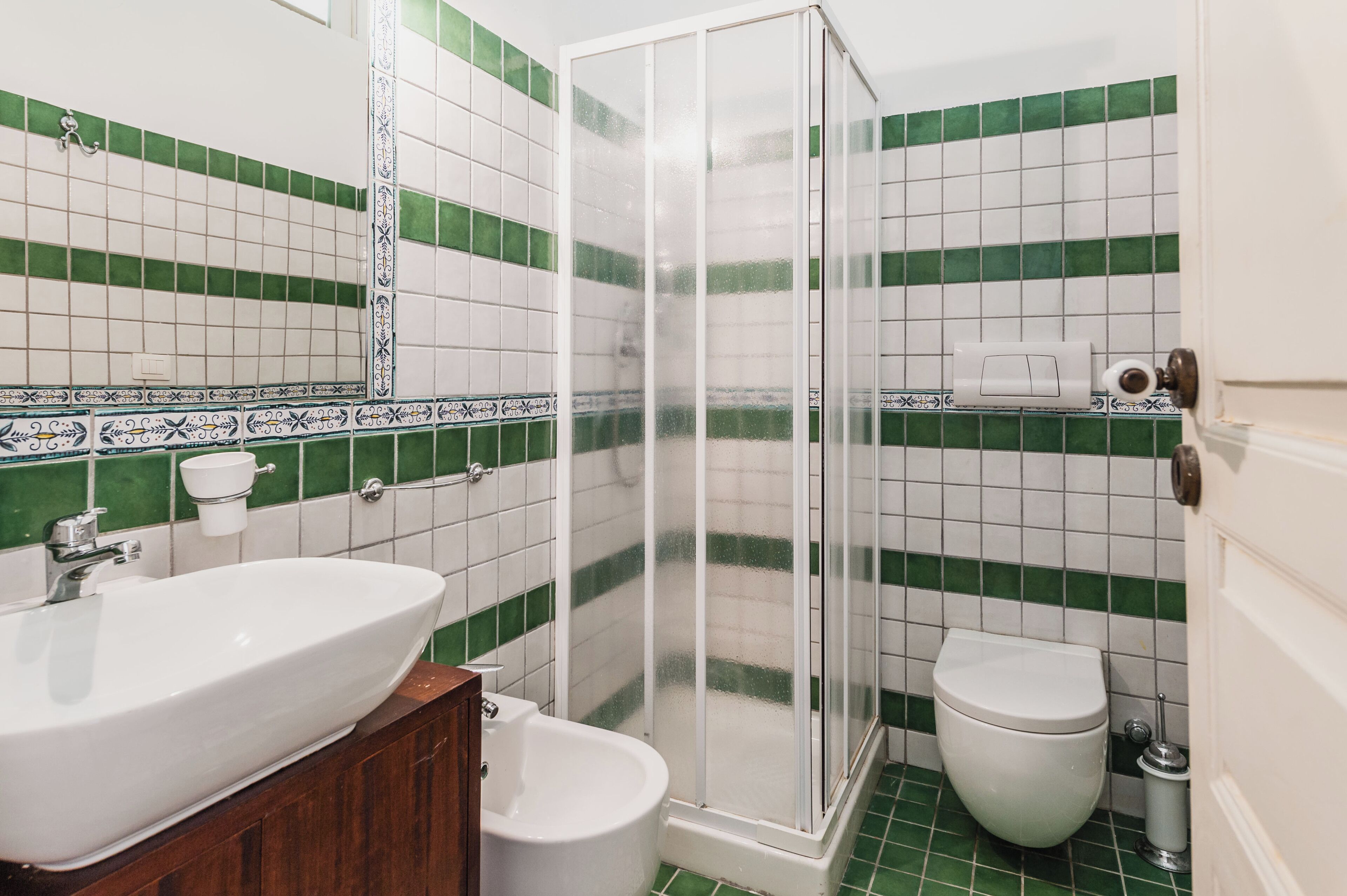A bathroom with a shower, toilet, and sink.