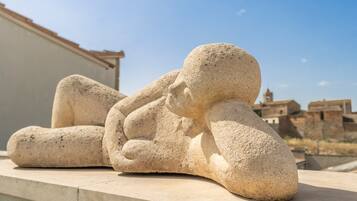 A stone sculpture of a reclining figure on a ledge.