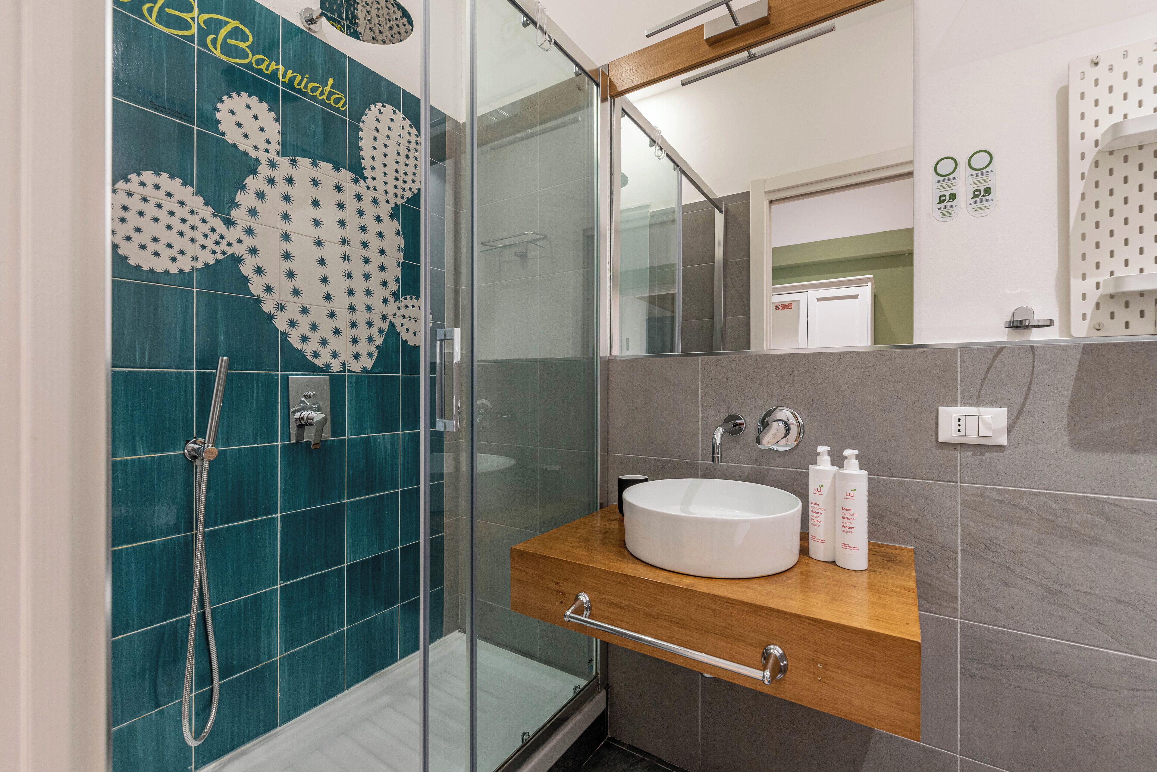 Ein modernes Badezimmer mit einer Duschkabine aus Glas, einem weißen Waschbecken und einer Holz-Kommode.