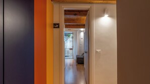 A hallway with a wooden ceiling, a door leading to a room with a bed, and a view of the outside. - Casa Abbanniata a Ballaro' by Wonderful Italy (Palermo)