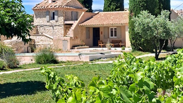 A stone house with a tiled roof, surrounded by a vineyard and tall cypress trees. - Domainde des Preyauts, le Mazet (Caromb)