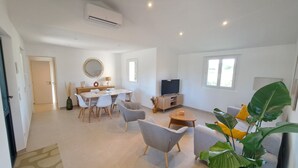 A spacious living area with a dining table, chairs, a sofa, a TV, and large windows. - Domainde des Preyauts, le Mazet (Caromb)