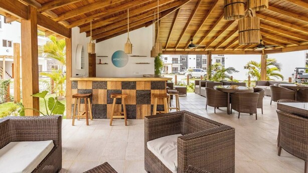 An outdoor bar area with wicker furniture and a checkered tile bar counter. - Bamboo Apartamento Las Terrenas (Las Terreras)