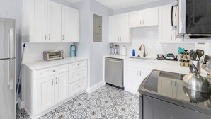 A modern kitchen with white cabinets, a built-in oven, a toaster, and a kettle. - 917- San Marco Sky Cottage, Pets OK, Near Arenas & Hospitals (Jacksonville)
