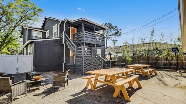 Une maison moderne dotée d’un patio aménagé avec du mobilier d’extérieur et un barbecue.