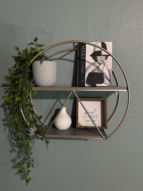 A wall-mounted shelf with a potted plant, a Vogue magazine, a framed quote, and a small vase. - Charming 3-bedroom vacation home just 4 minutes drive to Eiffel Tower (Paris)