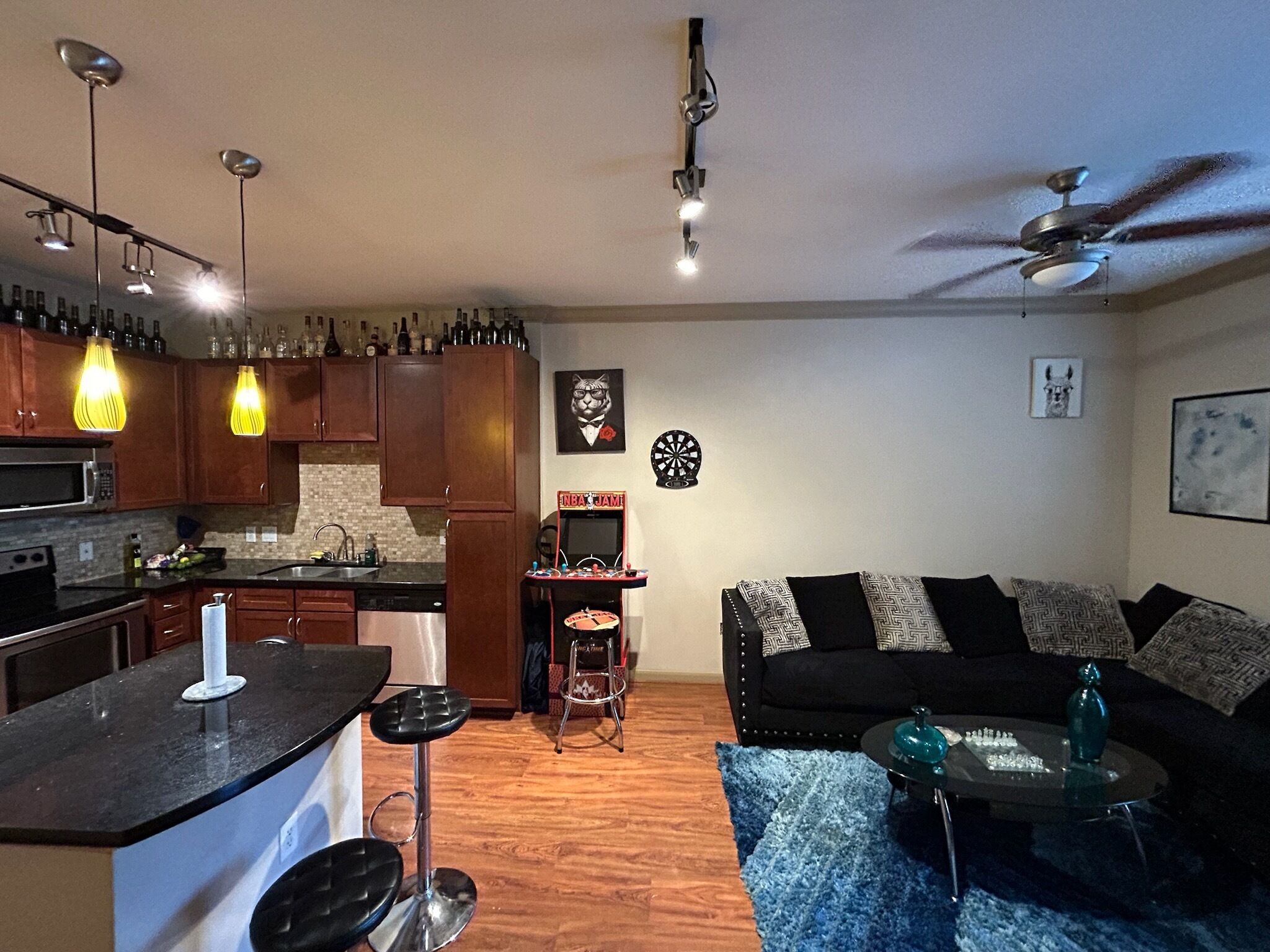 A modern kitchen with wooden cabinets, a bar area, and a dining table with chairs.