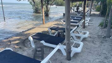 Di pantai, rumah kecil pinggir pantai gratis, dan kursi berjemur