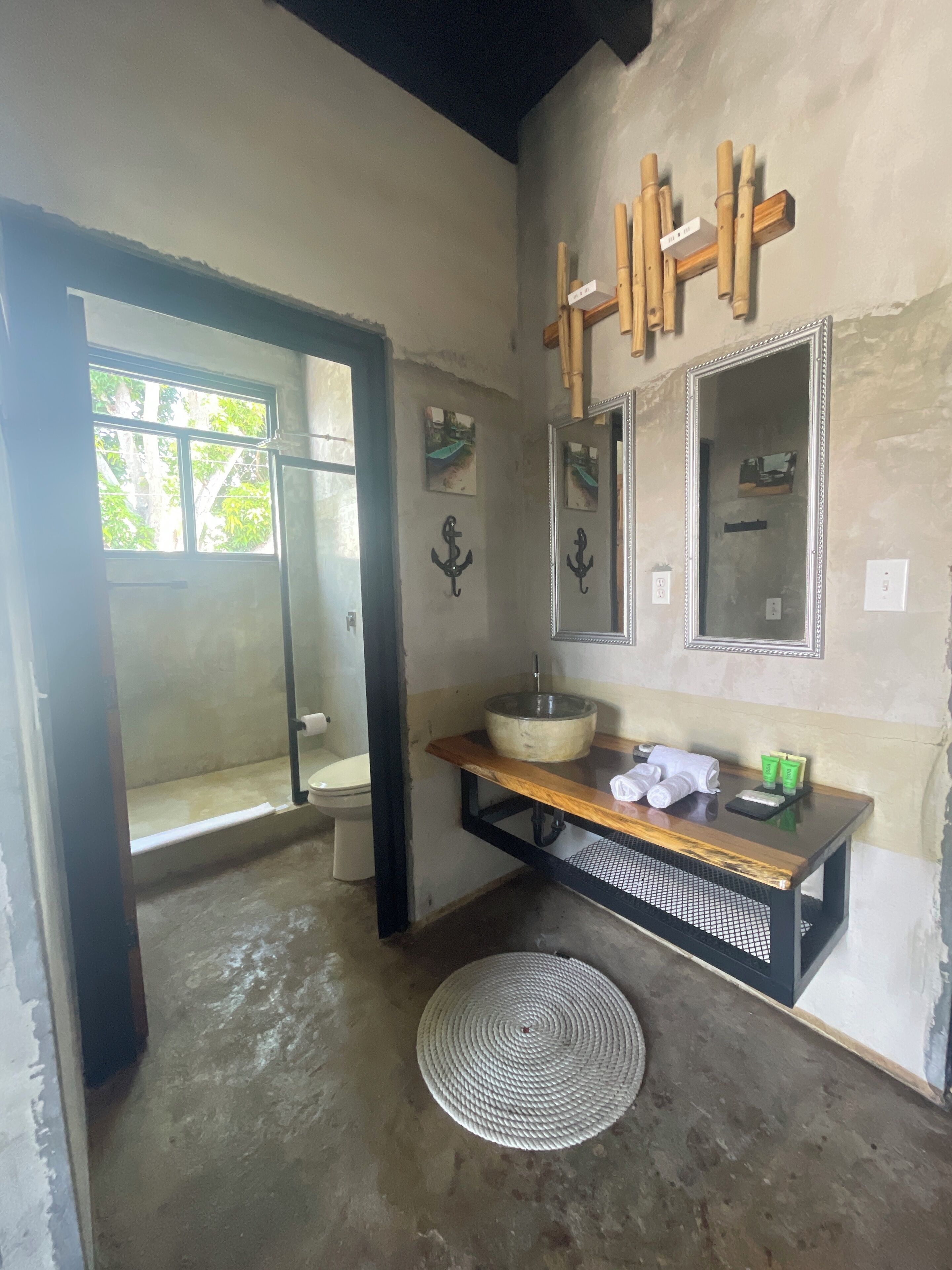 Une salle de bain avec un meuble-lavabo en bois, un grand miroir et des toilettes.