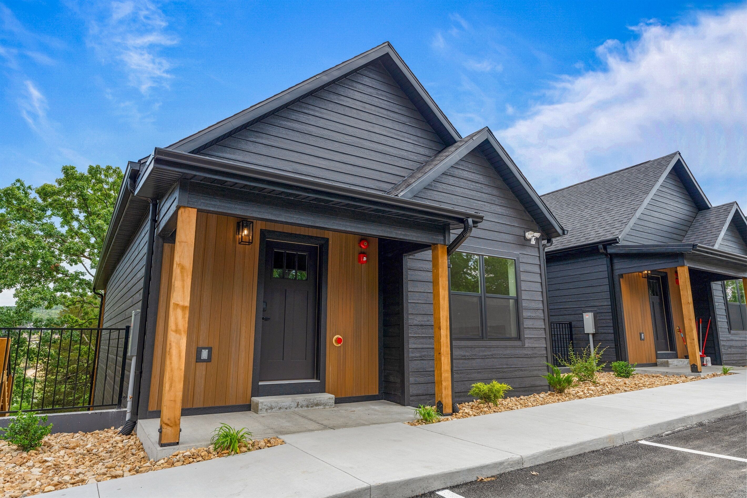 A modern building with a dark exterior, wooden accents, and a clear sky.