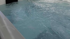 Un jacuzzi con vistas a un paisaje verde.