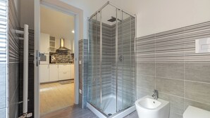 A modern bathroom with a glass shower enclosure, a bidet, and a toilet. - Al Khalisa Apartment by Wonderful Italy (Palermo)
