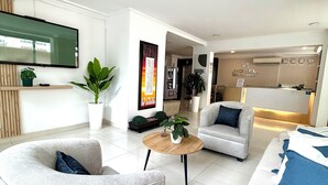 Ein modernes Wohnzimmer mit Flachbildfernseher, zwei Sofas, einem Couchtisch und einem Essbereich mit Bar.