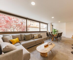 Un salon moderne avec un canapé, une table basse et un coin repas.
