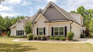 A two-story house with a gabled roof, a front porch, and a well-maintained lawn. - Senoia luxury Secluded Home w/ Master on Main (Senoia)