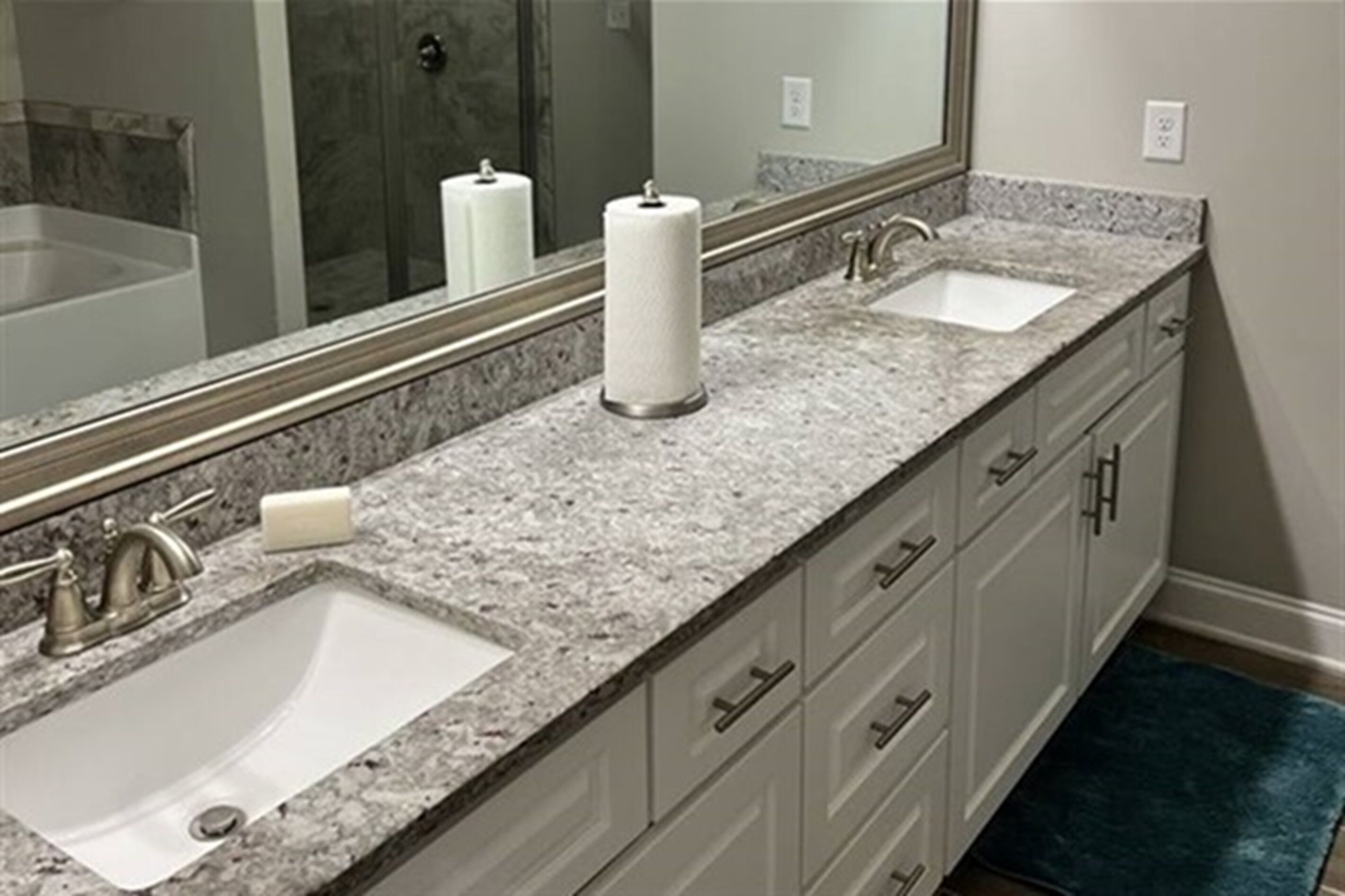Un bagno con due lavabi, un grande specchio e un piano di marmo.