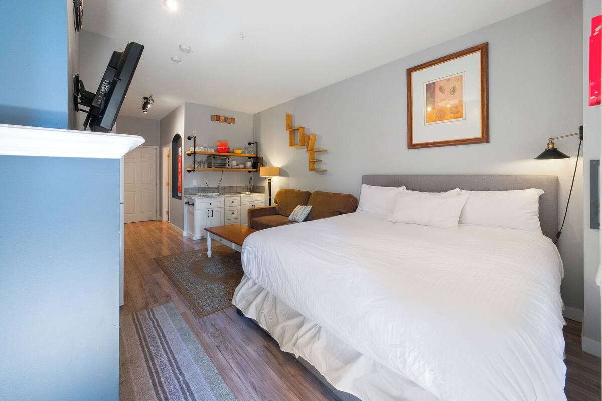 A bedroom with a large bed, a desk, and a chair.