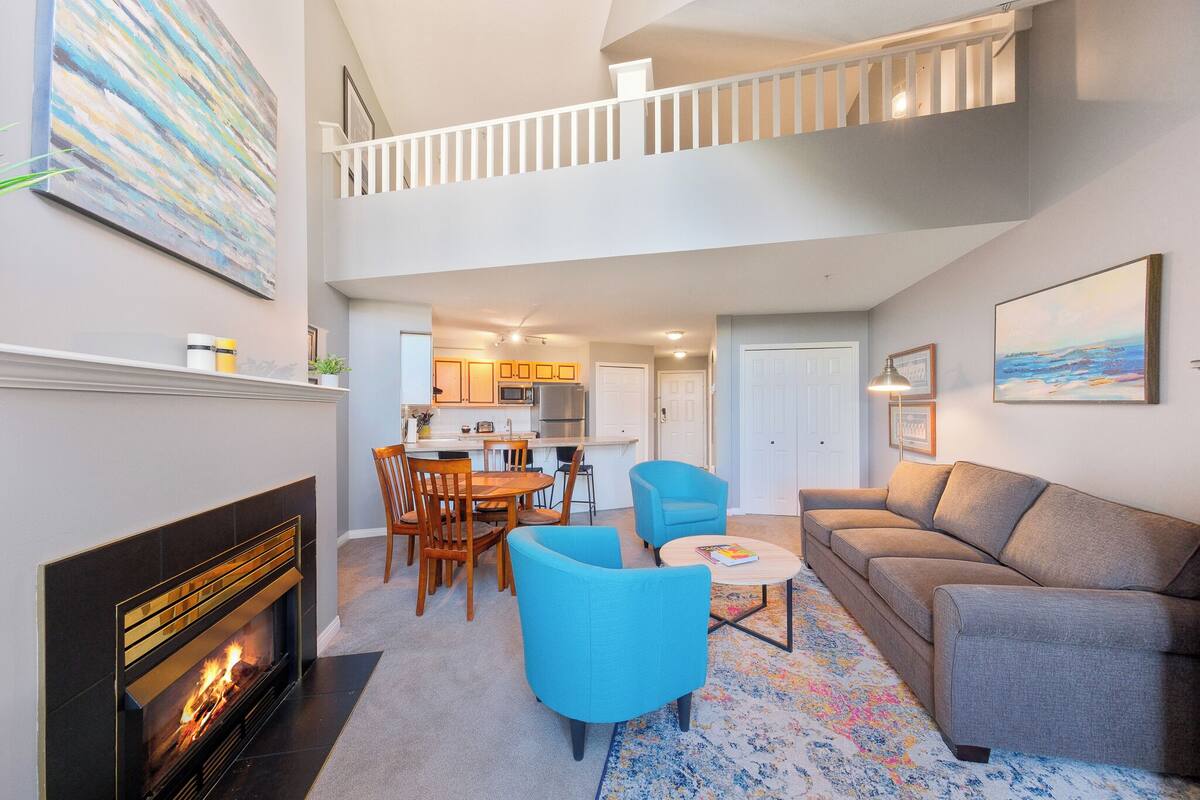 A spacious living area with a fireplace, a dining table, and a sofa.