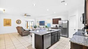 A modern kitchen with granite countertops, stainless steel appliances, and a central island. - Tropical Desert Oasis. New built! Family friendly. Grill,Tiki bar&Mountain view. (Maricopa)