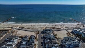 Zona residencial costera con casas, una playa y un muelle.