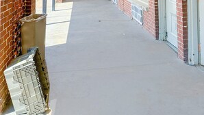 A long corridor with brick walls and white doors, leading to individual rooms. - Sunrise Inn By OYO Albany (Albany)