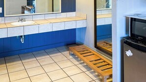 A bathroom with a large mirror, a sink, a toilet, and a shower. - Sunrise Inn By OYO Albany (Albany)