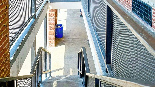 A covered corridor with brick walls, windows, and a metal railing. - Sunrise Inn By OYO Albany (Albany)