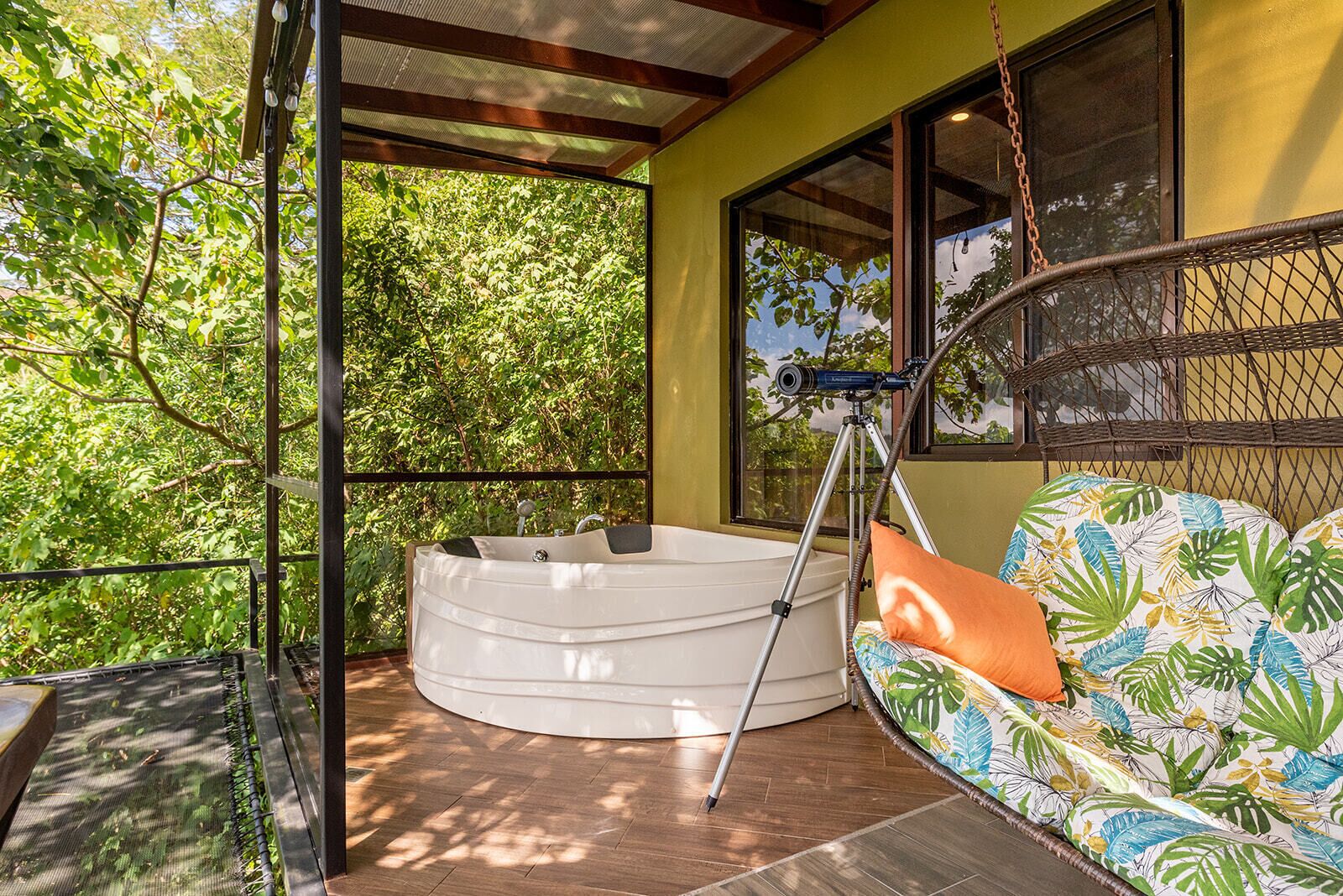 Ein Balkon mit Whirlpool, Teleskop und Hängematte.